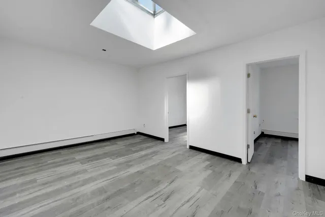an empty room with wooden floor and white walls