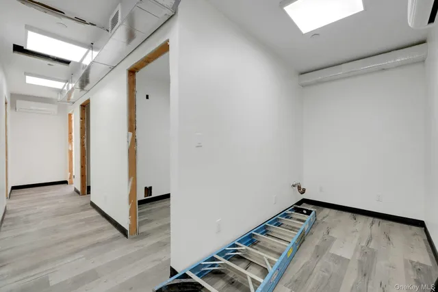 a view of a room with wooden floor and white walls