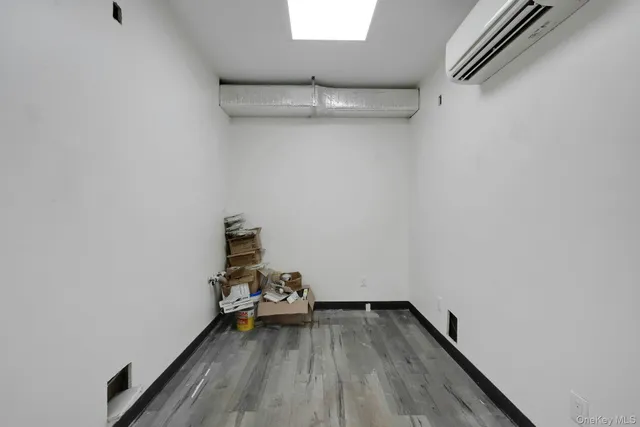 a view of hallway with window and wooden floor
