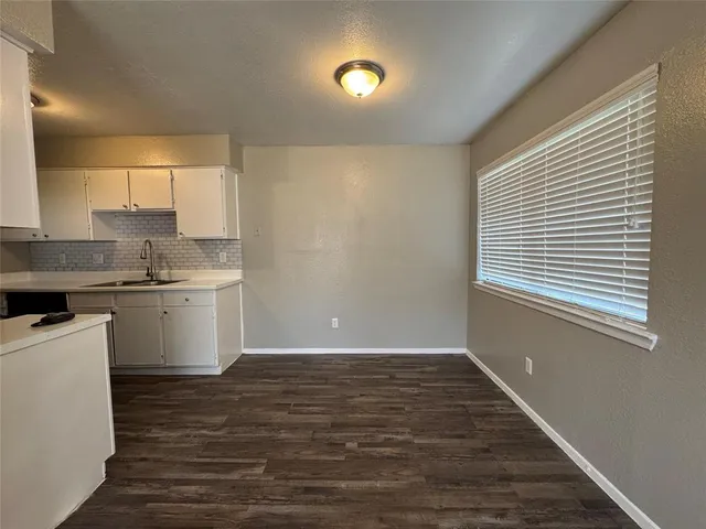 a kitchen with a sink cabinets stainless steel appliances and a window