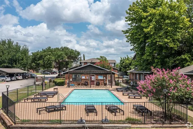 an aerial view of a house with swimming pool and furniture