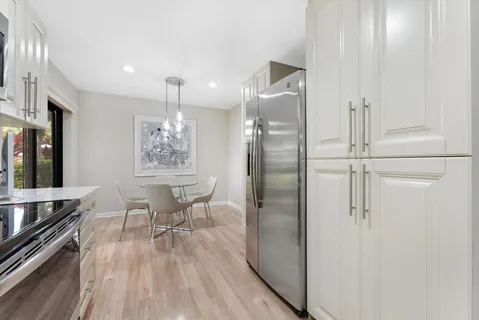 a front view of a house with a yard and potted plants