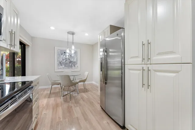 a front view of a house with a yard and potted plants