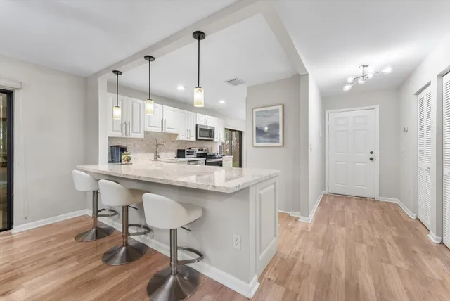 a kitchen with stainless steel appliances a refrigerator sink and microwave