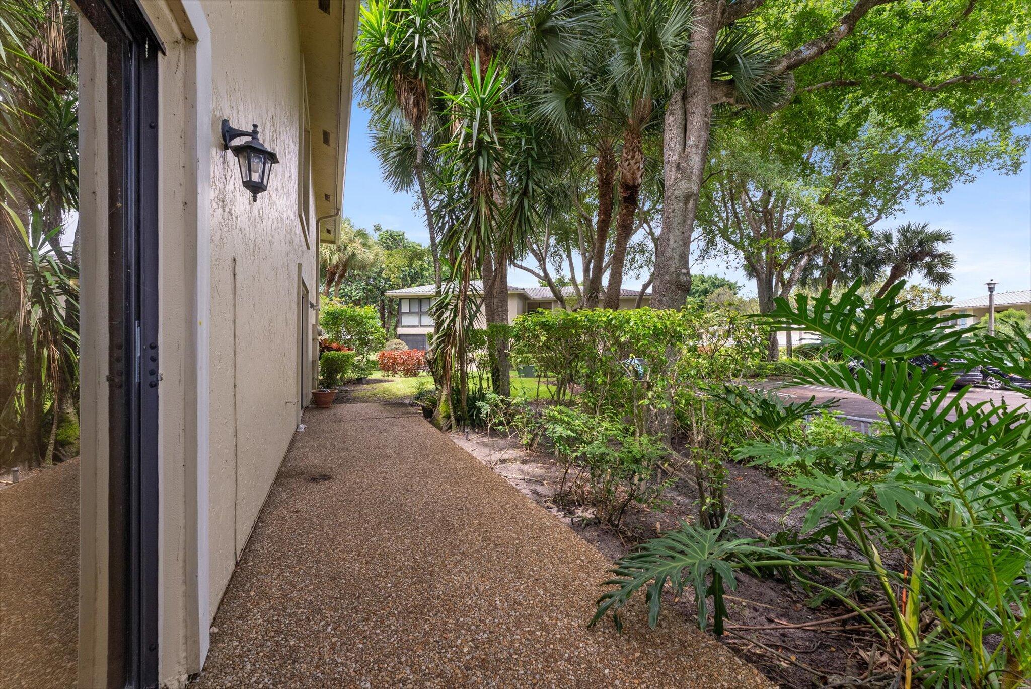 30 Westgate Lane, Unit 30G Boynton Beach, FL 33436 - Photo 23 of 58 a view of a pathway of a house with potted plants