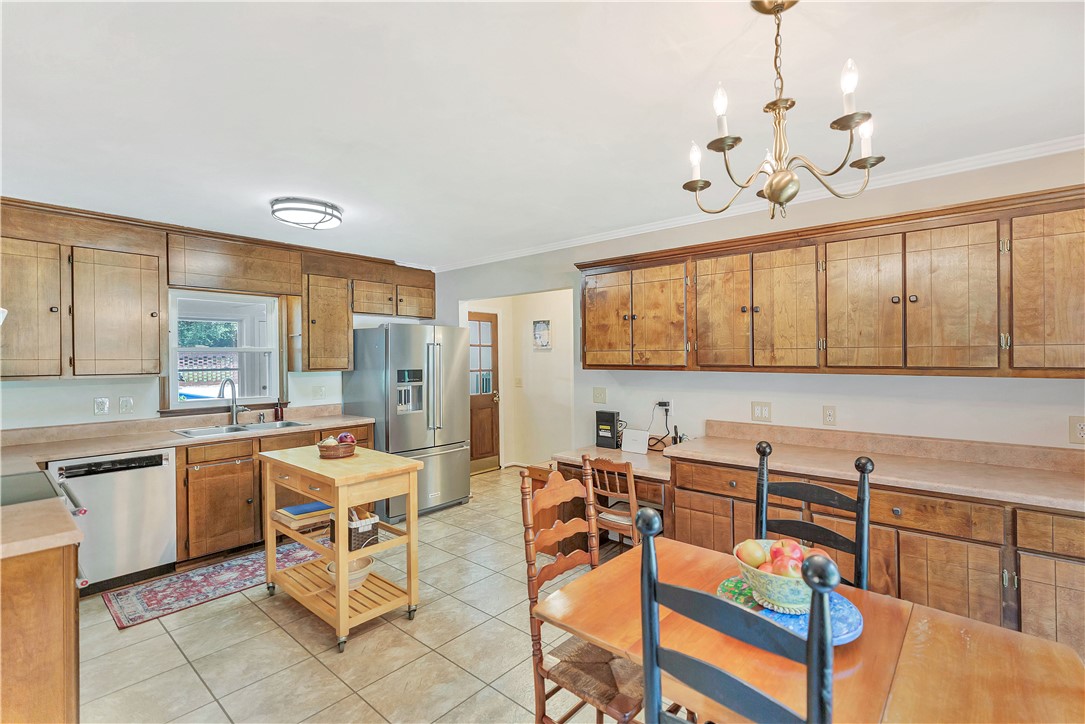 910 Chantilly Lane Anderson, SC 29625 - Photo 23 of 38 A well-lit kitchen with natural wood cabinetry and light-toned tile flooring creates a welcoming atmosphere.