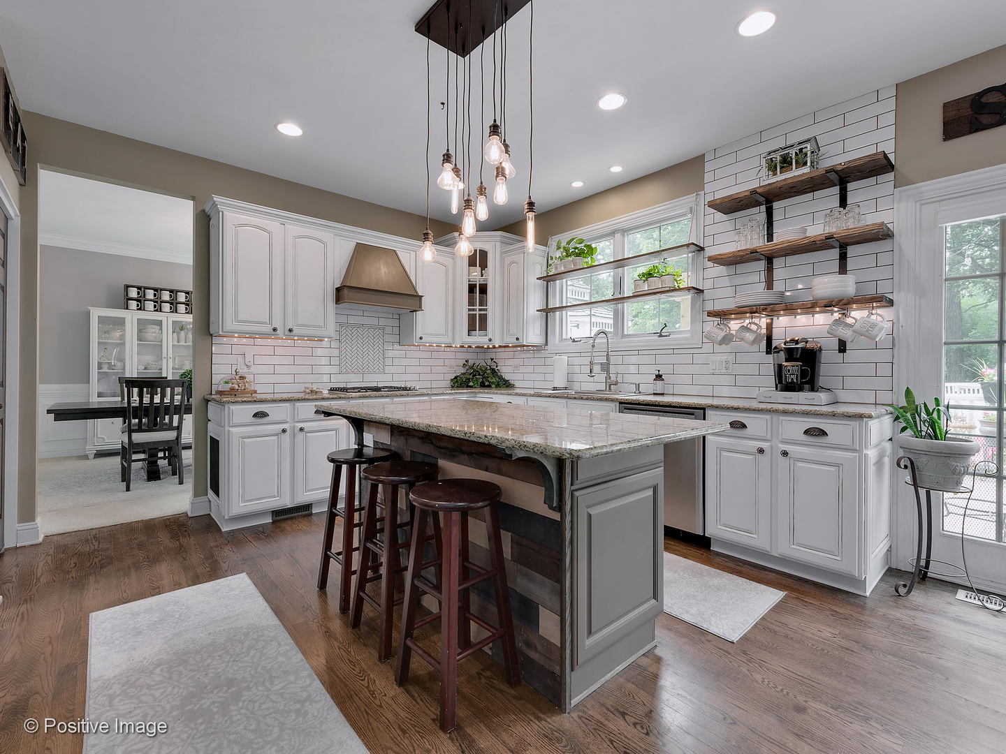 27W617 Garys Mill Road Winfield, IL 60190 - Photo 10 of 35 a kitchen with stainless steel appliances granite countertop a stove a sink dishwasher a refrigerator and a dining table with wooden floor