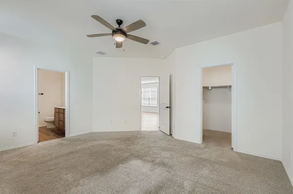 an empty room with windows and fan