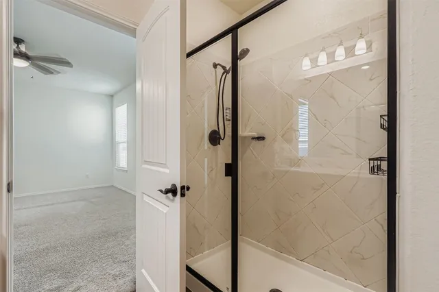 an empty room with windows and fan