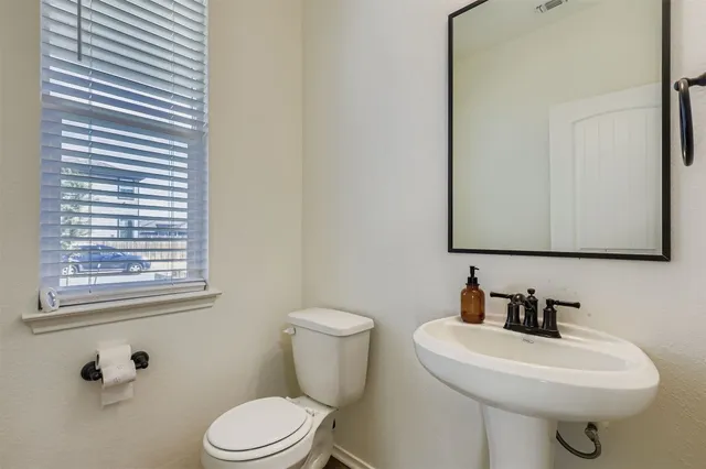 a view of a livingroom with a ceiling fan & windows