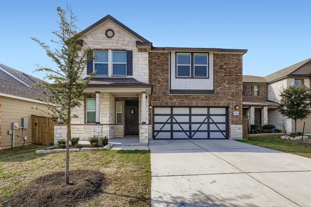 a front view of a house with a yard and garage