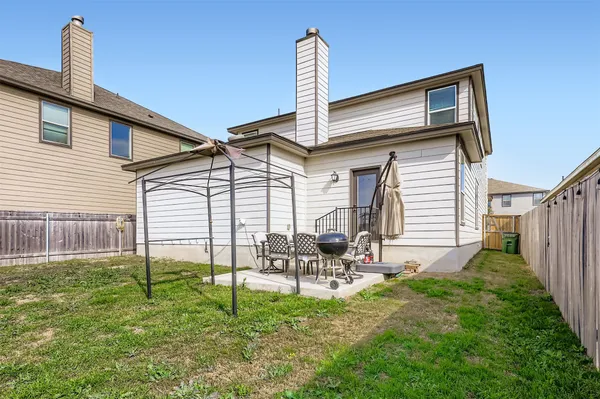 a view of a house with backyard and chairs