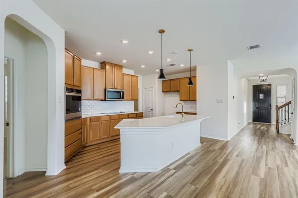 a large kitchen with a lot of counter space and wooden floor