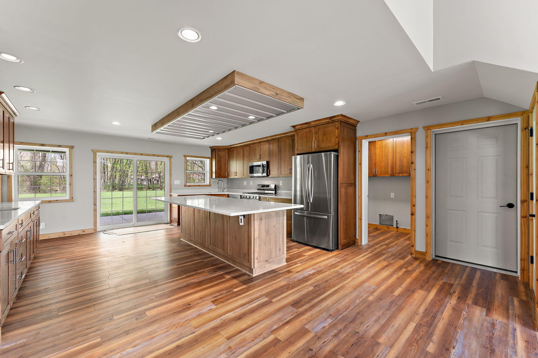 6631 Beach Street Knox, IN 46534 - Photo 9 of 41 a kitchen with stainless steel appliances granite countertop a refrigerator a sink dishwasher a stove and white countertops with wooden floor