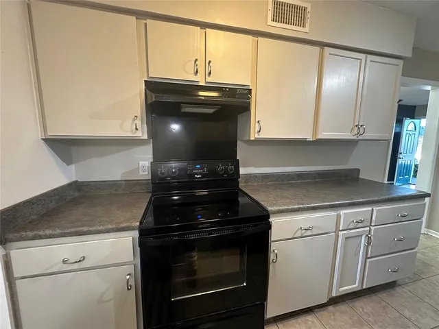 a kitchen with granite countertop white cabinets and stainless steel appliances