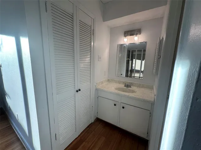 a bathroom with a granite countertop sink and a mirror