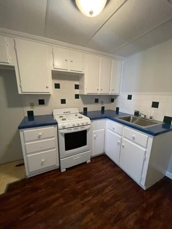 137 5th Street Fall River, MA 02721 - Photo 2 of 8 a kitchen with a white stove top oven and white cabinets