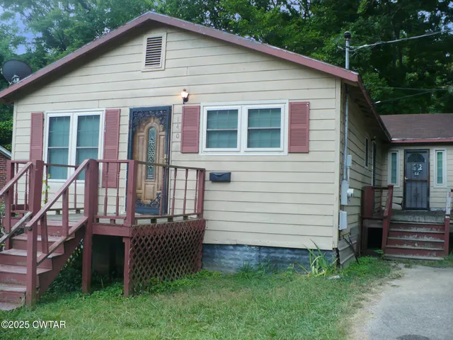 a view of a house with a yard and stairs