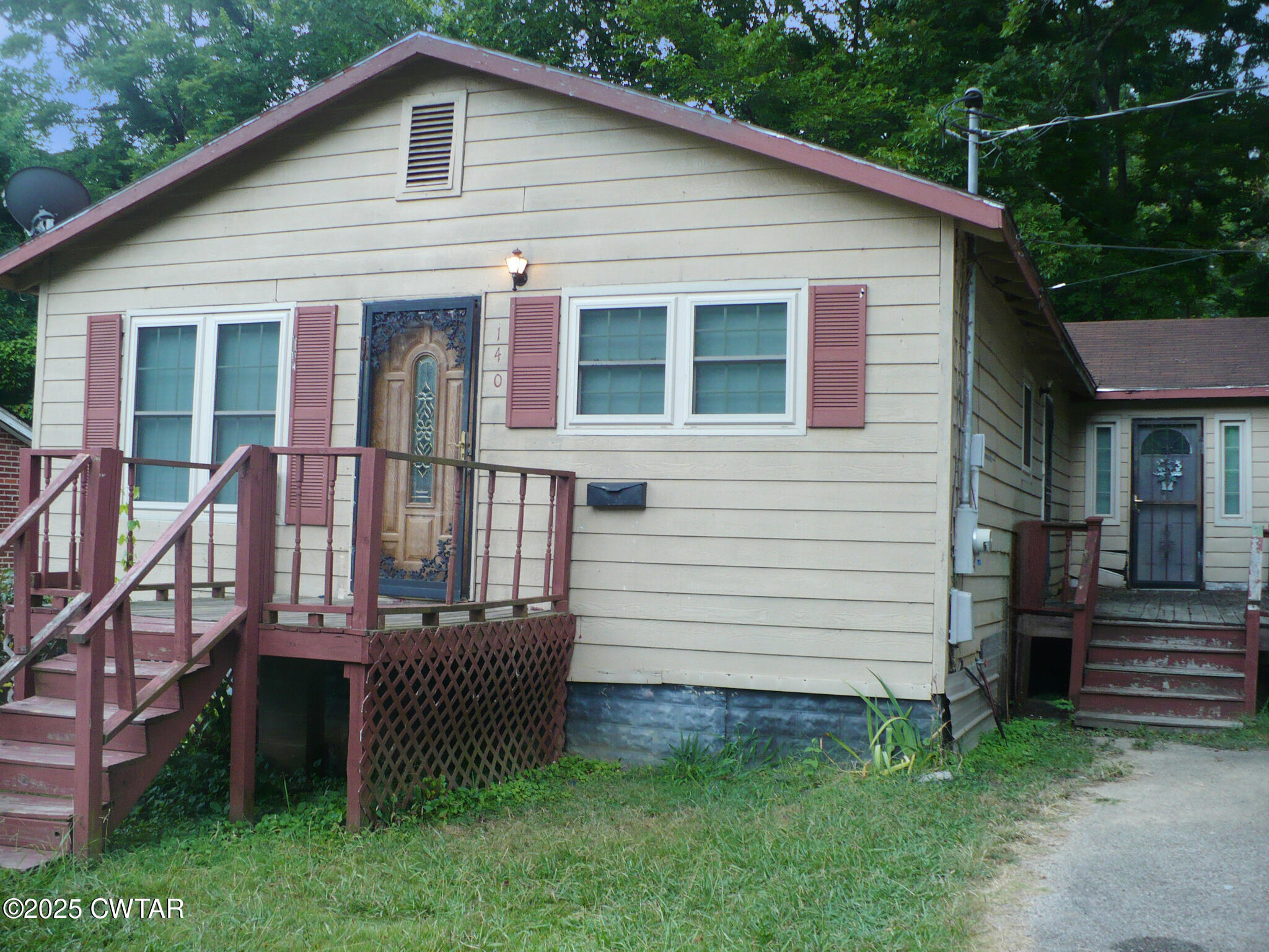a view of a house with a yard and stairs