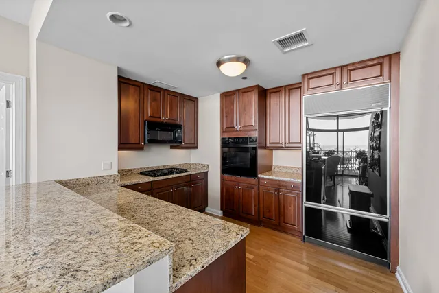 a kitchen with stainless steel appliances granite countertop a refrigerator and a stove top oven