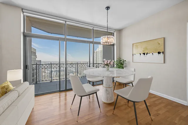 a dining room with furniture a chandelier and wooden floor