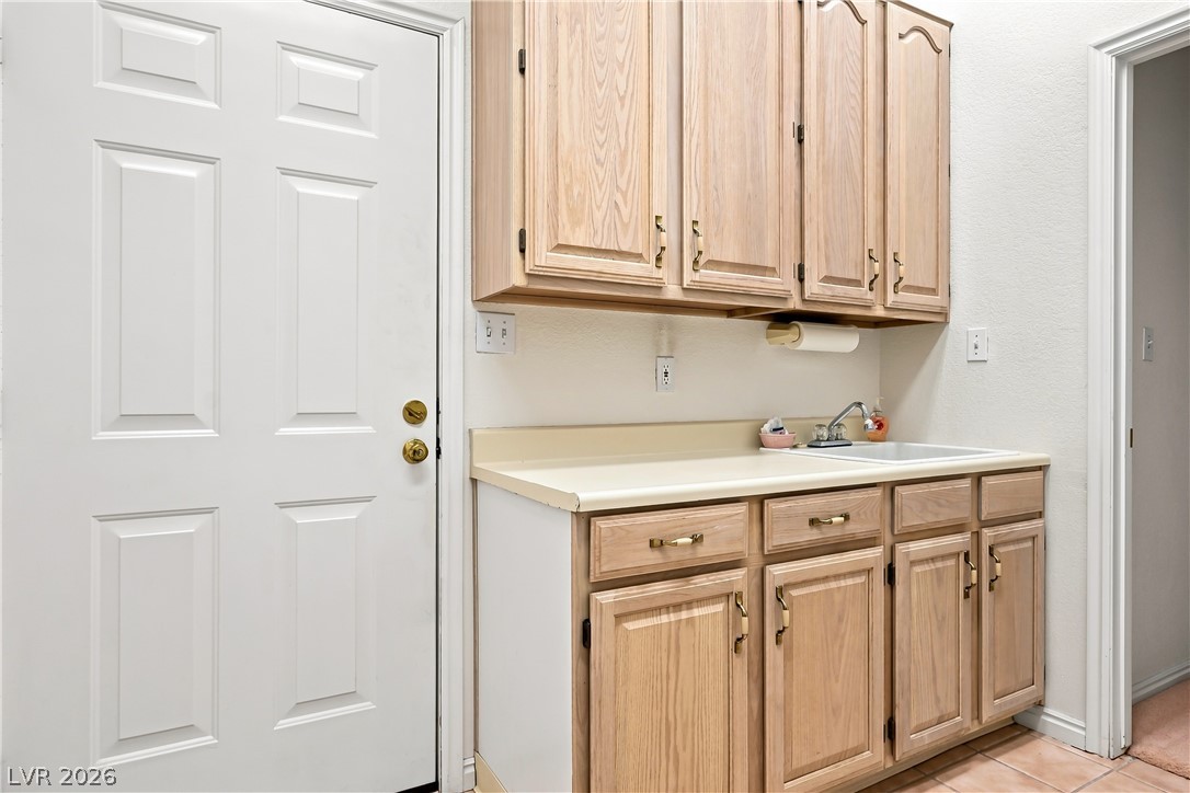 1068 Calico Ridge Drive Henderson, NV 89011 - Photo 26 of 38 Functional workspace features abundant oak cabinetry alongside a convenient utility sink.