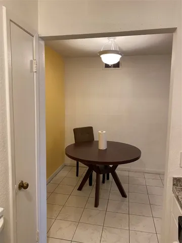a view of a room that has a table and chairs in it