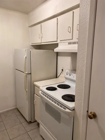 a kitchen with refrigerator and cabinets