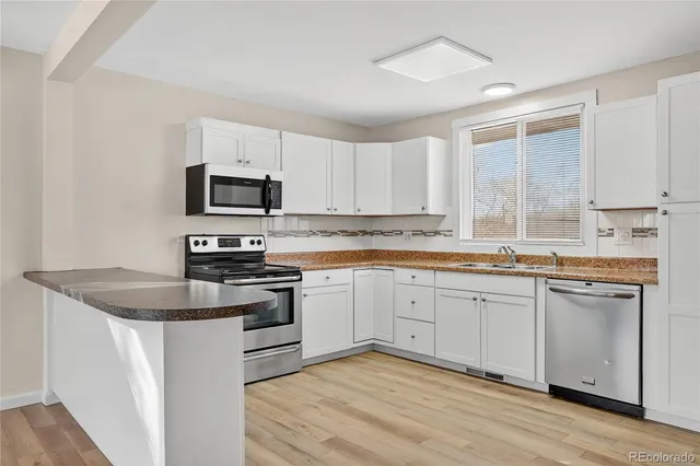 a kitchen with stainless steel appliances a refrigerator sink and cabinets