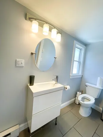 a bathroom with a toilet sink and mirror