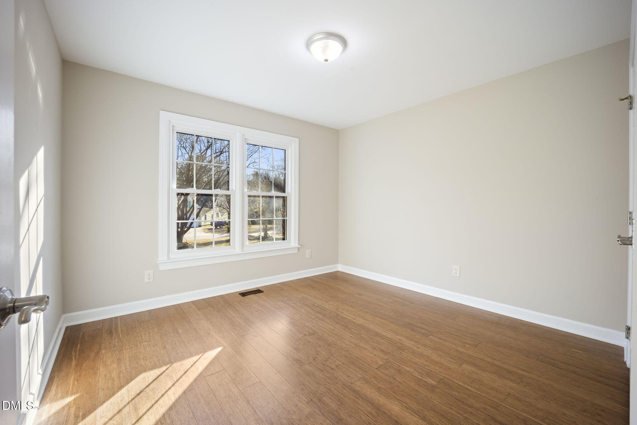 912 Broadhaven Drive Raleigh, NC 27603 - Photo 13 of 51 an empty room with wooden floor and windows