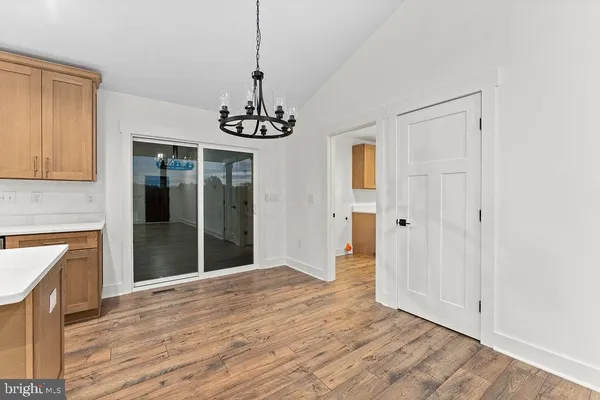 a view of empty room with wooden floor and fireplace