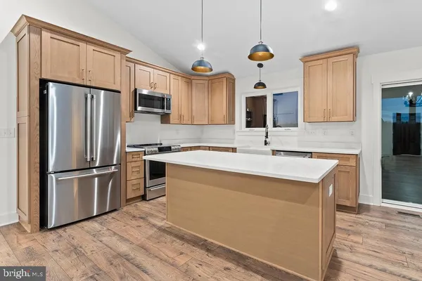a kitchen with kitchen island granite countertop a sink cabinets and stainless steel appliances