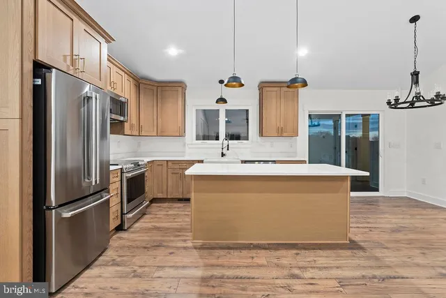 a large kitchen with stainless steel appliances granite countertop a sink a refrigerator and a stove