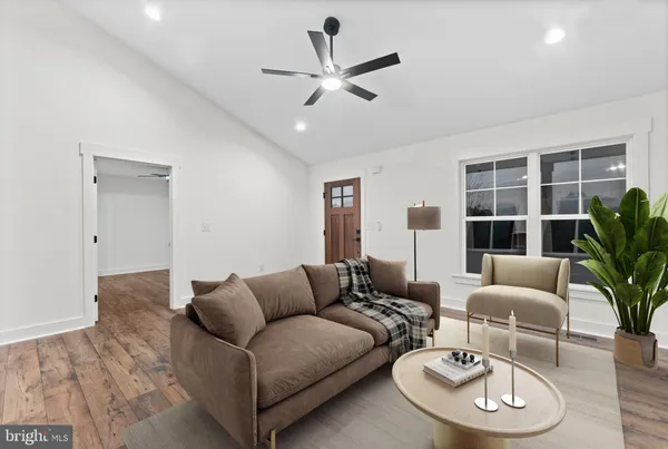 a living room with furniture potted plant and a large window