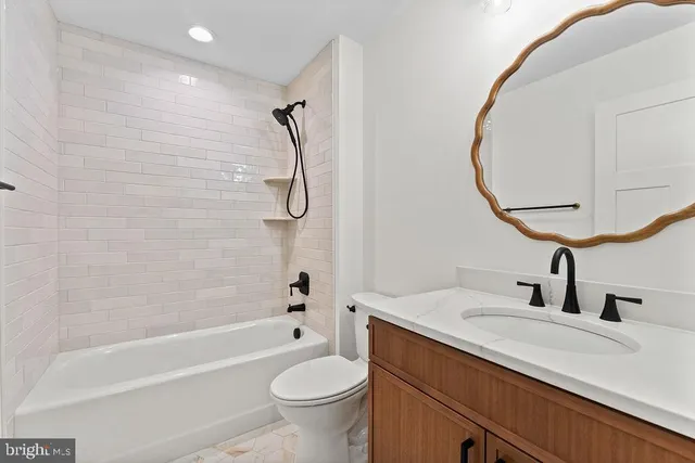 a bathroom with a sink a toilet and a mirror