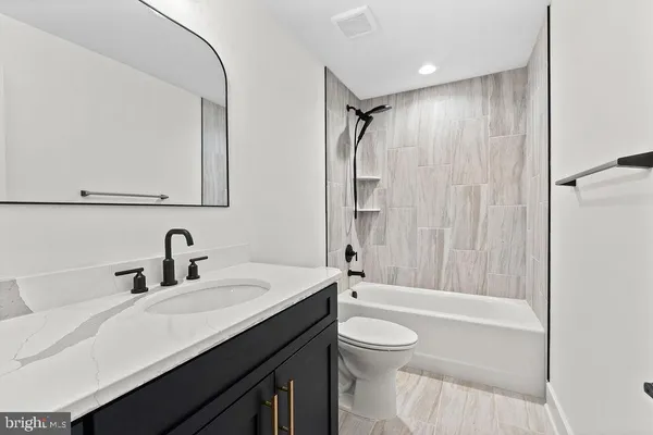 a bathroom with a granite countertop sink toilet and shower