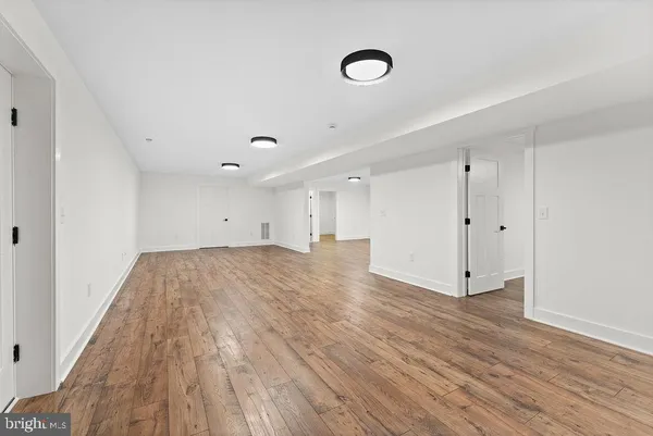 a view of empty room with wooden floor