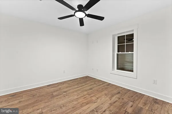 an empty room with a window and a fan