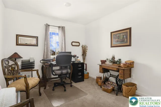 a view of a workspace with furniture and a window