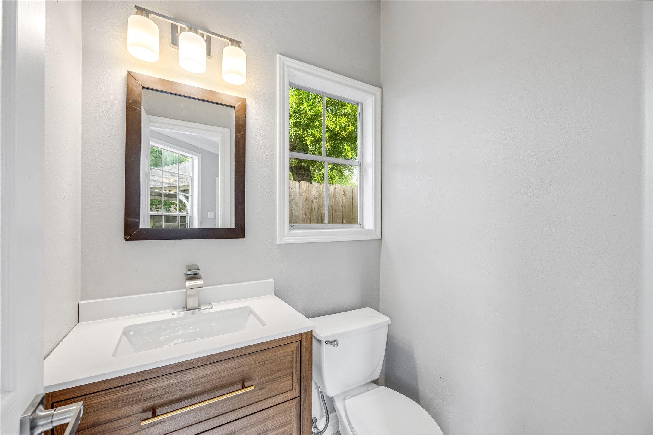 9806 Tanager Lane Conroe, TX 77385 - Photo 16 of 28 a bathroom with a toilet sink vanity and mirror