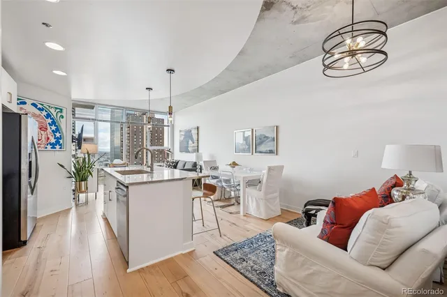 a living room with furniture large windows and wooden floor