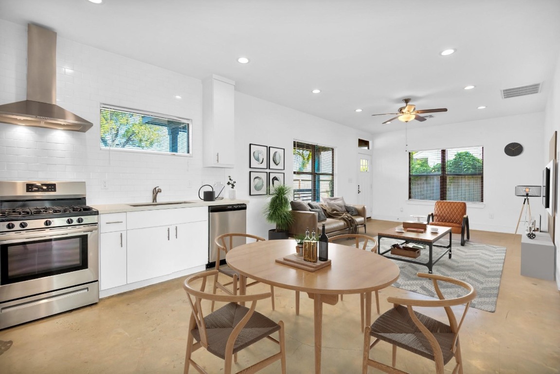 a kitchen with a dining table chairs and white cabinets