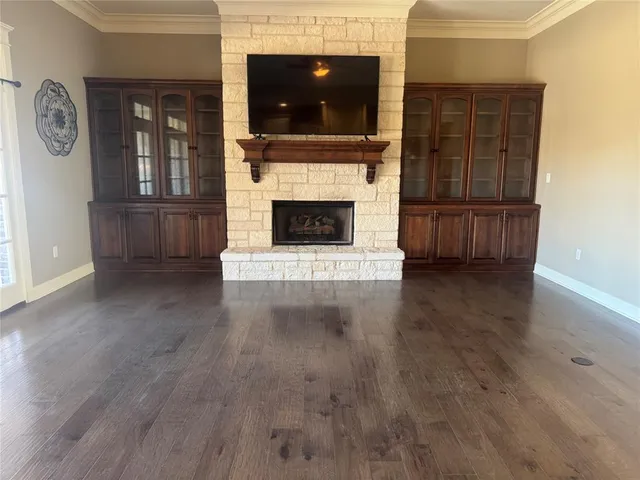 a kitchen with kitchen island granite countertop wooden floors and refrigerator