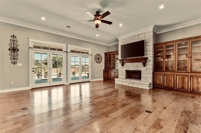 a view of a livingroom with a flat screen tv ceiling fan and a fireplace