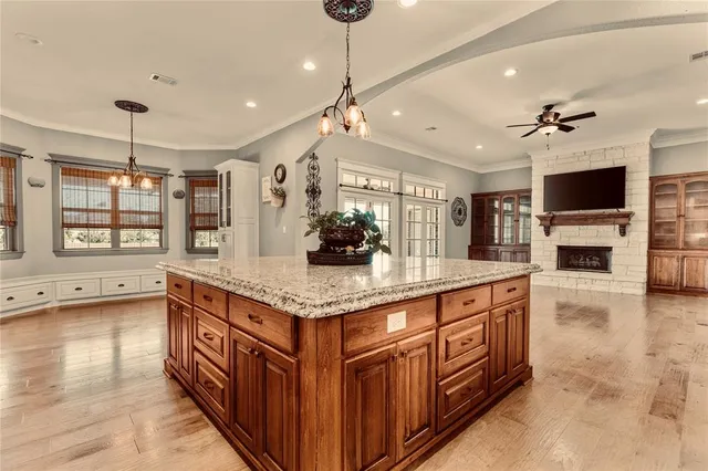 a kitchen with stainless steel appliances kitchen island granite countertop a stove a sink and a refrigerator