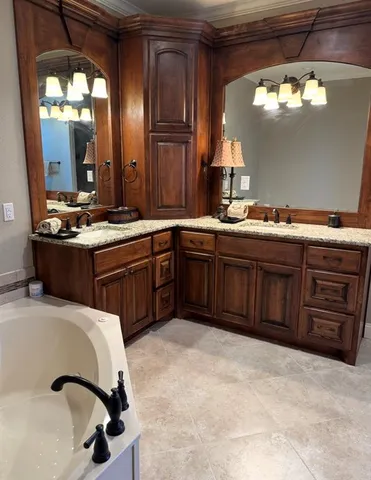 a spacious bedroom with a bed and a chandelier