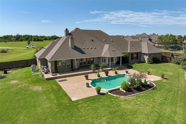 an aerial view of a house with swimming pool garden and patio