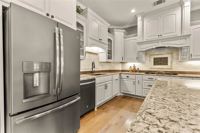 a kitchen with granite countertop a refrigerator stove top oven and sink