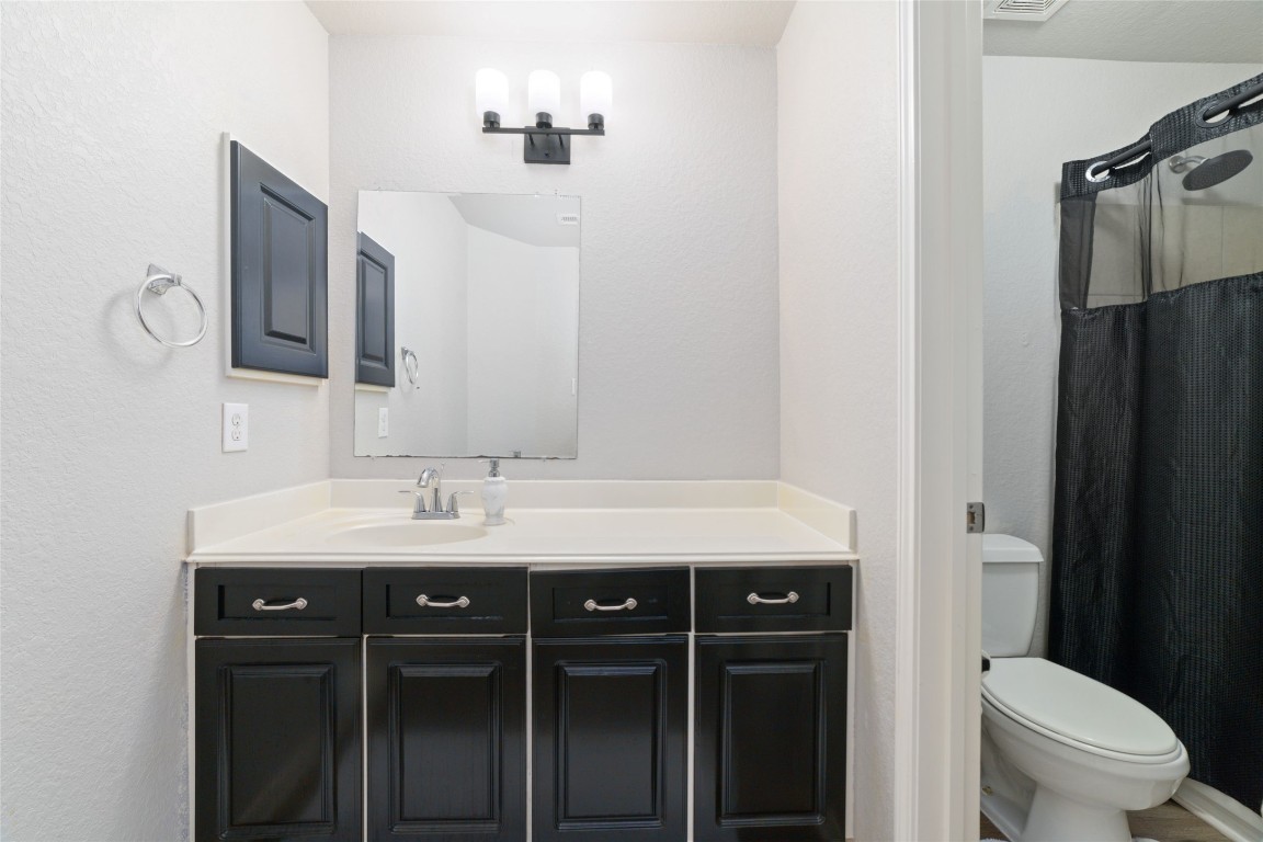 3038 Winchester Rnch Trail Katy, TX 77493 - Photo 25 of 29 a bathroom with a granite countertop sink a toilet a mirror and shower